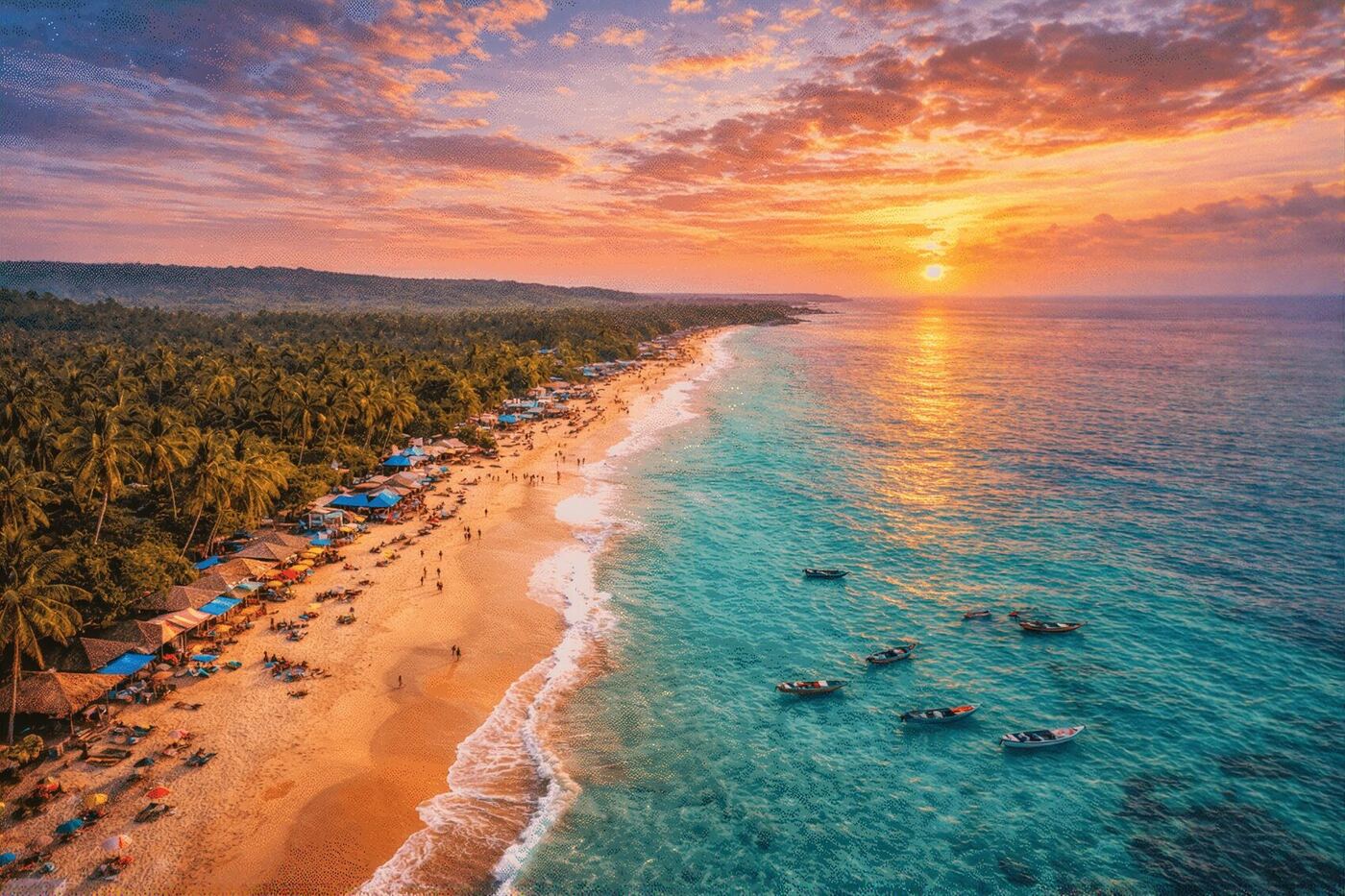 An aerial view of a South Goa beach at sunset, with turquoise water, fishing boats and palm fringed sand